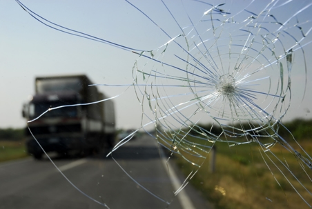 Truck viewed through broken glass as a symbol of a pending accident