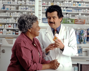 Pharmacist showing woman a prescription bottle