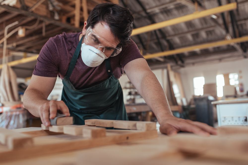 young woodworker wearing facemask in workshop